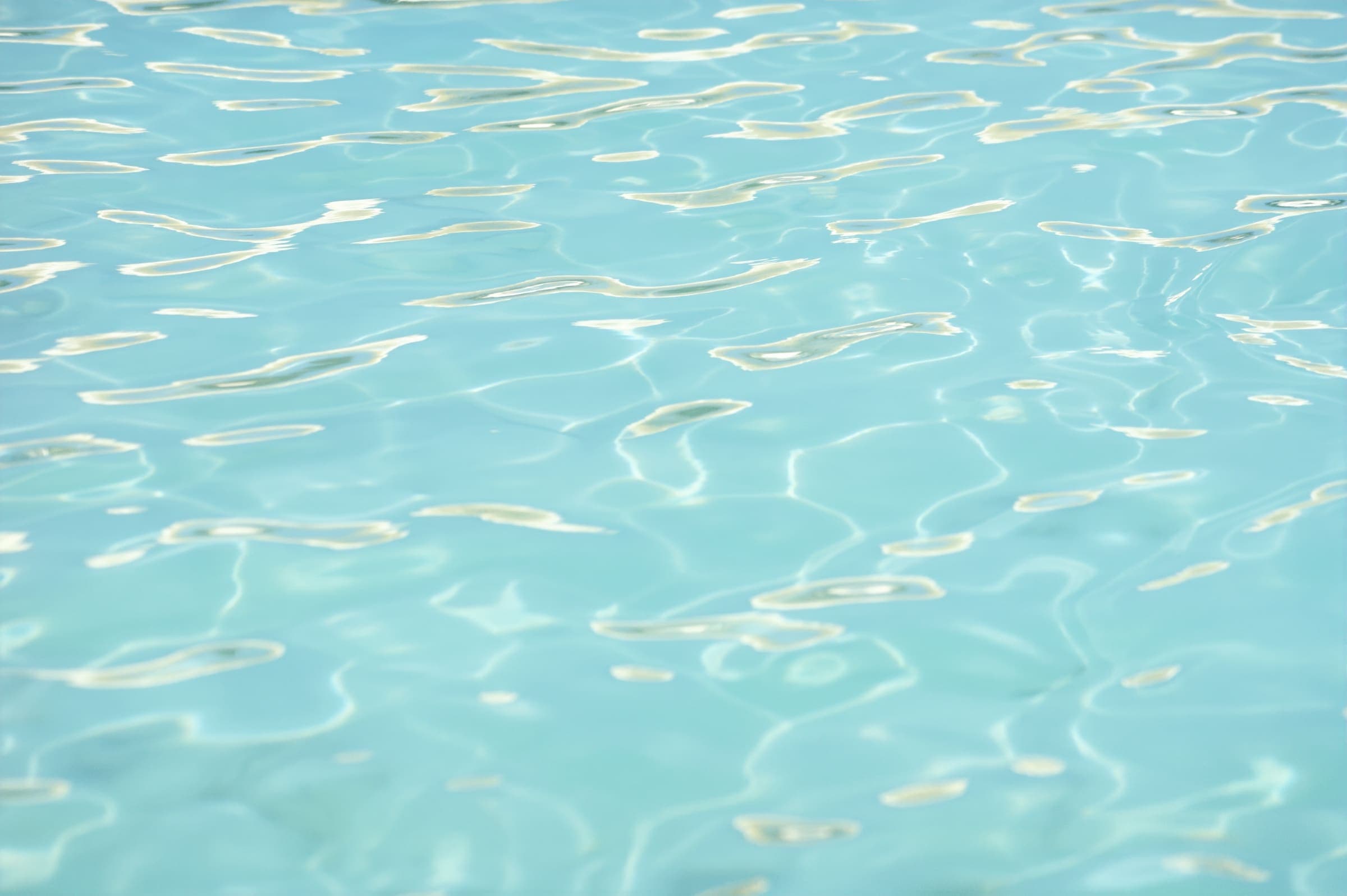 Reflejos del sol sobre agua turquesa y transparente