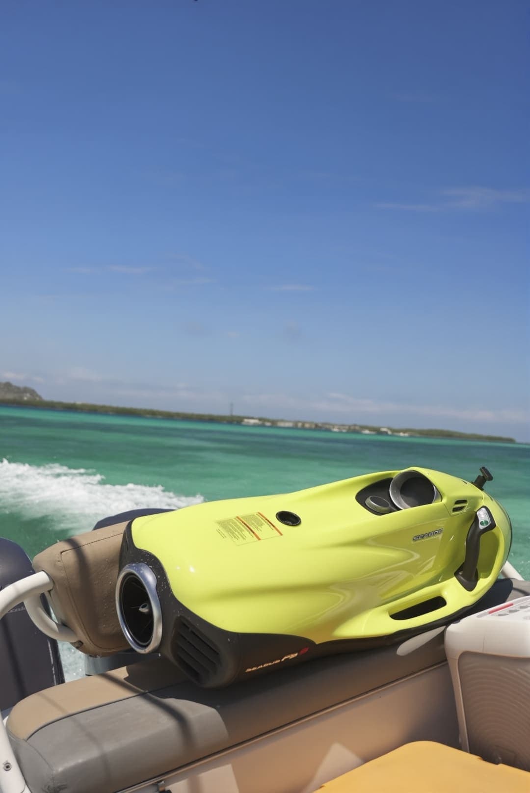 Propulsor submarino amarillo en la popa de la lancha, con la estela detrás